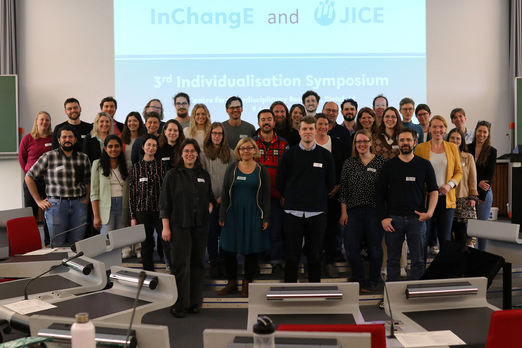 Eine Gruppe von Wissenschaftlerinnen und Wissenschaftlern steht vor einer Leinwand.