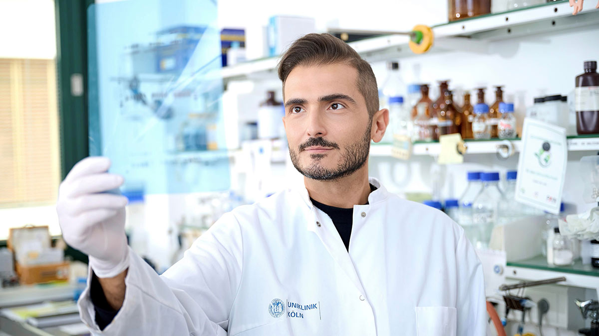 Dr. Gianmaria Liccardi steht in seinem Labor und betrachtet eine Folie mit Forschungsergebnissen.