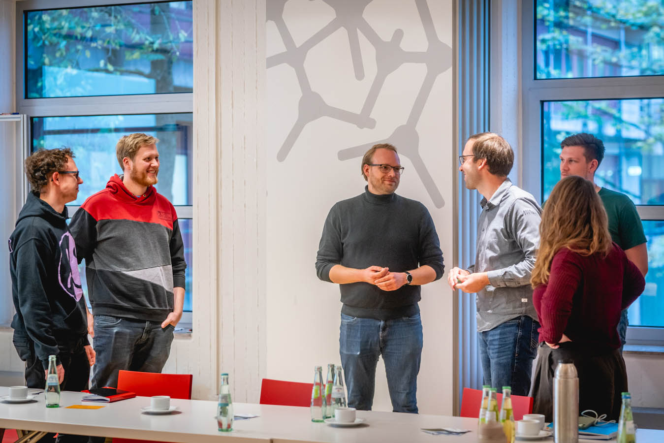 Sechs Workshopteilnehmende stehen beisammen und unterhalten sich.